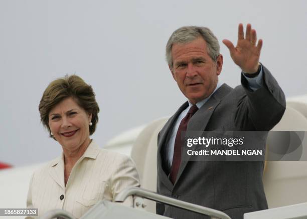 President George W. Bush waves while stepping off Air Force One with First Lady Laura Bush 27 August 2006 upon arrival at Andrews Air Force Base in...