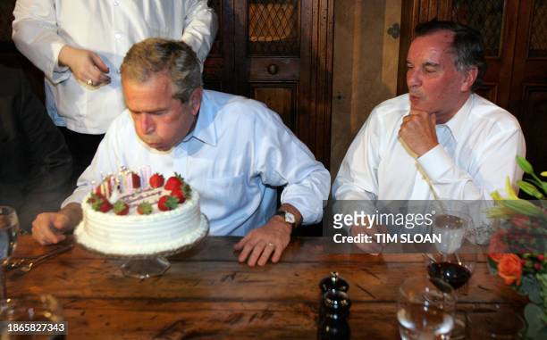 President George W. Bush blows out the candles on his birthday cake beside Chicago Mayor Richard M. Daley during a private dinner party at the...