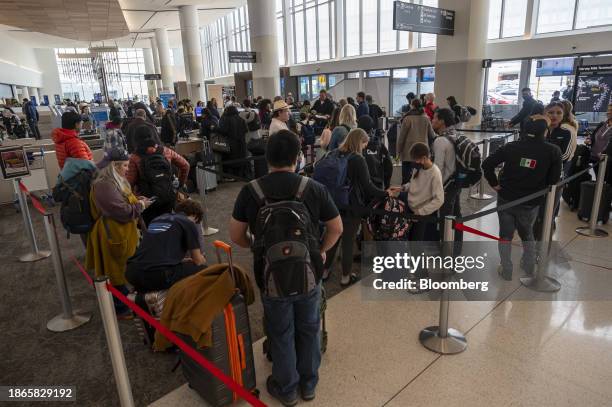 Travelers wait to check in at the American Airlines ticket counter at San Francisco International Airport in San Francisco, California, US, on...