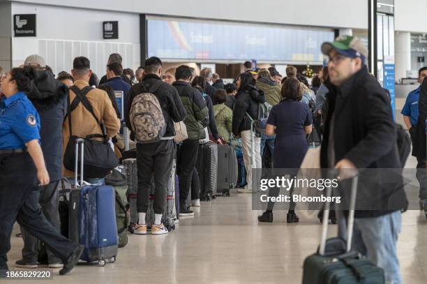 Travelers wait to check in at the American Airlines ticket counter at San Francisco International Airport in San Francisco, California, US, on...