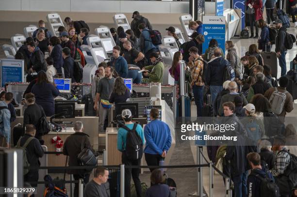Travelers wait to check in at the American Airlines ticket counter at San Francisco International Airport in San Francisco, California, US, on...