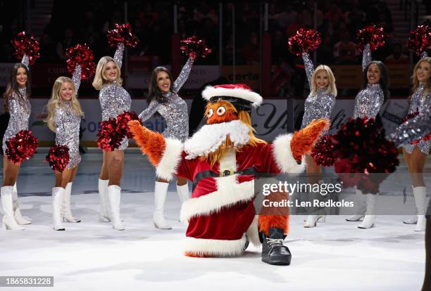 Gritty, the mascot of the Philadelphia Flyers, poses on the ice during a pregame holiday performance with the Flyers Dance Team prior to his team's...