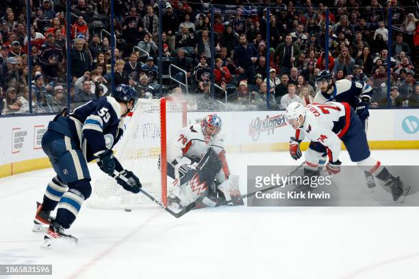 John Carlson of the Washington Capitals looks for a rebound as Charlie Lindgren stops a shot by Yekor Chinakhov of the Columbus Blue Jackets during...