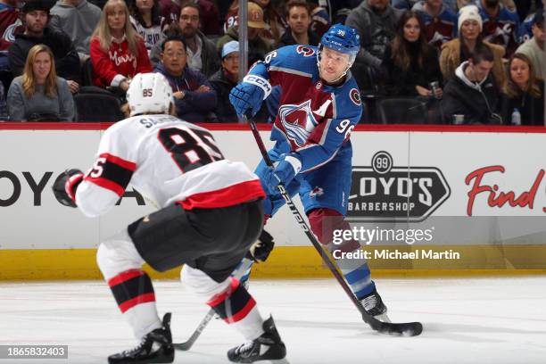 Mikko Rantanen of the Colorado Avalanche shoots while Jake Sanderson of the Ottawa Senators defends at Ball Arena on December 21, 2023 in Denver,...