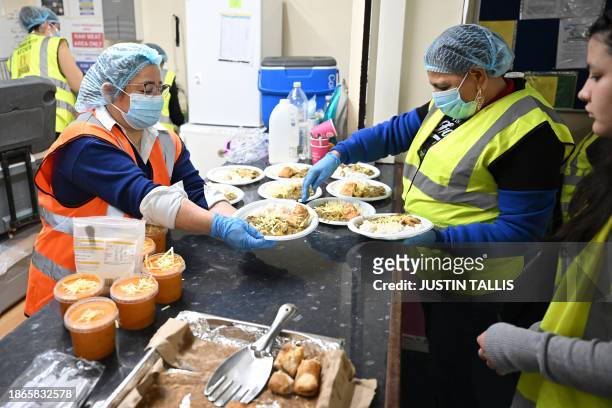 Volunteers serve plates of food at the Oca Community Kitchen in south London on December 16, 2023. Jose Luis Garcia Basabe is a Basque chef who lives...