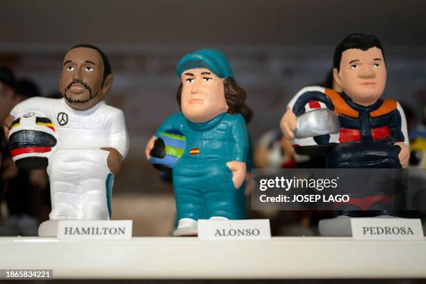 Catalan typical clay figurines, called "caganers" , depicting F1 pilots Lewis Hamilton and Fernando Alonso, and MotoGP rider Dani Pedrosa , are...