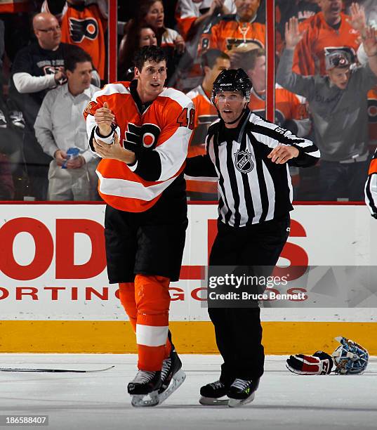 Vincent Lecavalier of the Philadelphia Flyers is escourted off the ice following his third period fight against Steve Oleksy of the Washington...