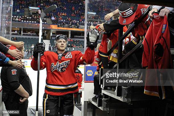 Matt Stajan of the Calgary Flames greets fans after the pre game warmup against the Detroit Red Wings at Scotiabank Saddledome on November 1, 2013 in...