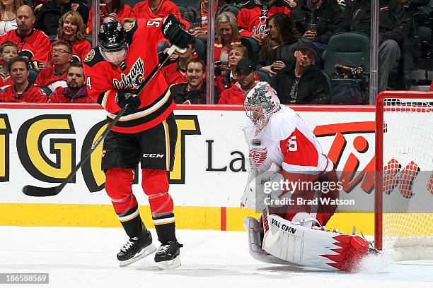 Jimmy Howard of the Detroit Red Wings makes a save on a shot deflected by David Jones of the Calgary Flames at Scotiabank Saddledome on November 1,...