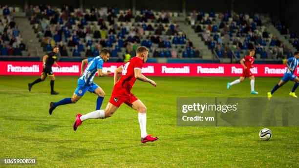 joueurs de football masculins menant le ballon - joueur de football photos et images de collection