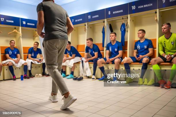 soccer coach talking with players in locker room - dressing room stock pictures, royalty-free photos & images