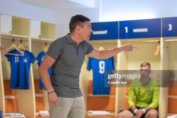 soccer coach speaking to players in locker room - coach yelling stock pictures, royalty-free photos & images