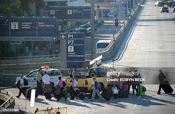 Arriving passengers leave the airport following many hours before being allow to deplane after a shooting incident at Los Angeles International...