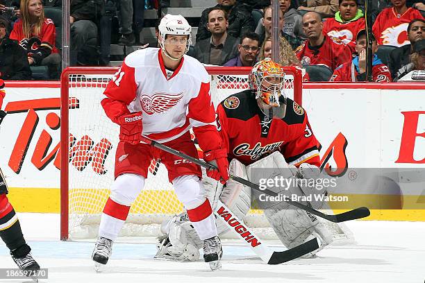 Tomas Tatar of the Detroit Red Wings skates in front of Joey MacDonald of the Calgary Flames at Scotiabank Saddledome on November 1, 2013 in Calgary,...