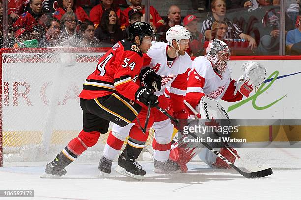 David Jones of the Calgary Flames skates against Niklas Kronwall and Jimmy Howard of the Detroit Red Wings at Scotiabank Saddledome on November 1,...