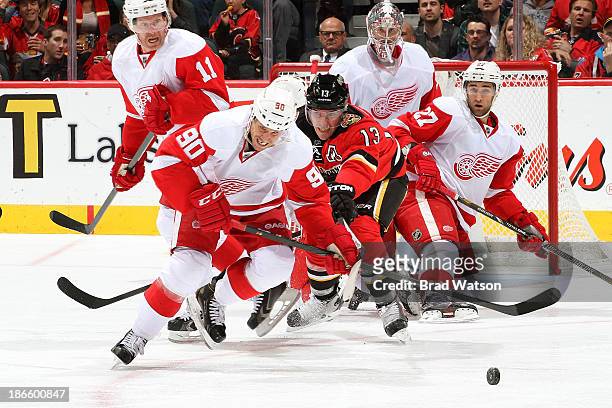 Stephen Weiss of the Detroit Red Wings and Michael Cammalleri of the Calgary Flames reach for the puck at Scotiabank Saddledome on November 1, 2013...