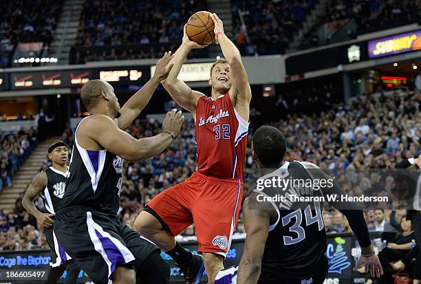 Blake Griffin of the Los Angeles Clippers shoots over Chuck Hayes and Jason Thompson of the Sacramento Kings during the third quarter at Sleep Train...