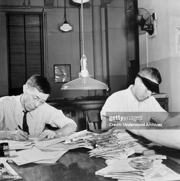 Copyreaders at the foreign desk in the newsroom of the New York Times newspaper, New York, New York, September, 1942.