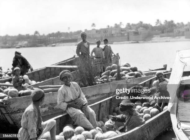 Iraqi boys with barges of watermelons on the Tigris River, Baghdad, Iraq, 1932.