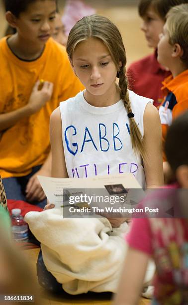 Eliana Smith of Ashburn, went to religious school with Gabriella Miller. She is reading the program while wearing the self-made tshirt in Gabriella...