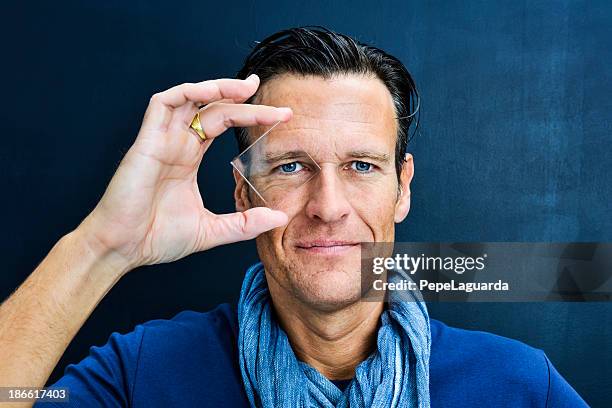 vision: middle aged man looking through lens - lens eye stock pictures, royalty-free photos & images