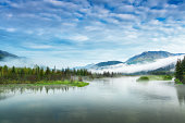 Lake and mountain landscape with early-morning fog