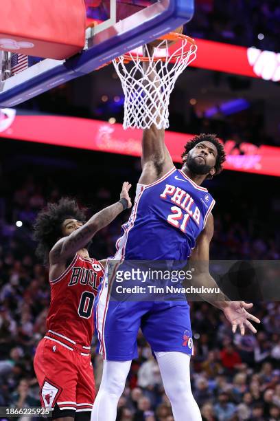 Joel Embiid of the Philadelphia 76ers dunks past Coby White of the Chicago Bulls during the third quarter at the Wells Fargo Center on December 18,...