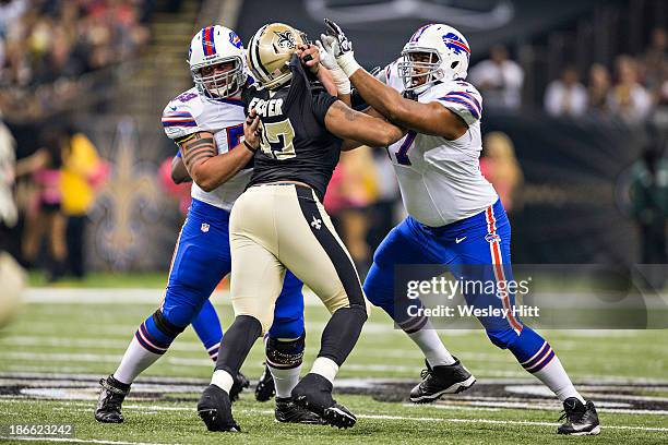 Doug Legursky and Cordy Glenn of the Buffalo Bills blocks Glenn Foster of the New Orleans Saints at Mercedes-Benz Superdome on October 27, 2013 in...