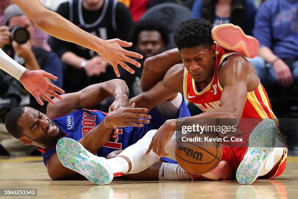 De'Andre Hunter of the Atlanta Hawks draws a foul as he battles for a loose ball against Alec Burks of the Detroit Pistons during the fourth quarter...