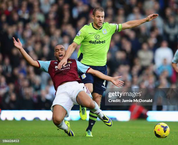 Ron Vlaar of Aston Villa challenges for the ball with Winston Reid of West Ham United during the Barclays Premier League match between West Ham...