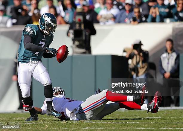 Quarterback Michael Vick of the Philadelphia Eagles is attempts to escape the grab by defensive end Mathias Kiwanuka of the New York Giants during...
