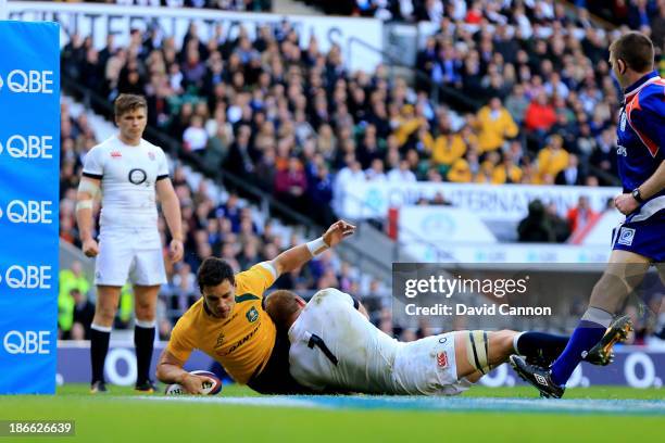 Matt Toomua of Australia scores the opening try despite the tackle from Chris Robshaw of England during the QBE International match between England...