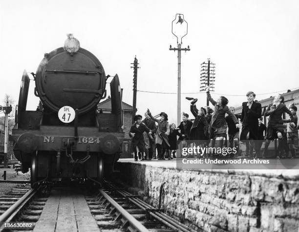 Children who were evacuated from London during WWII excitedly greet the Southern Railway Evacuation Special train as it pulls in with their parents...