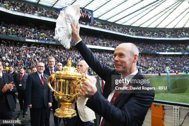 Former coach Sir Clive Woodward carries the Rugby World Cup as members of the 2003 Rugby World Cup winning team parade the trophy at half time during...