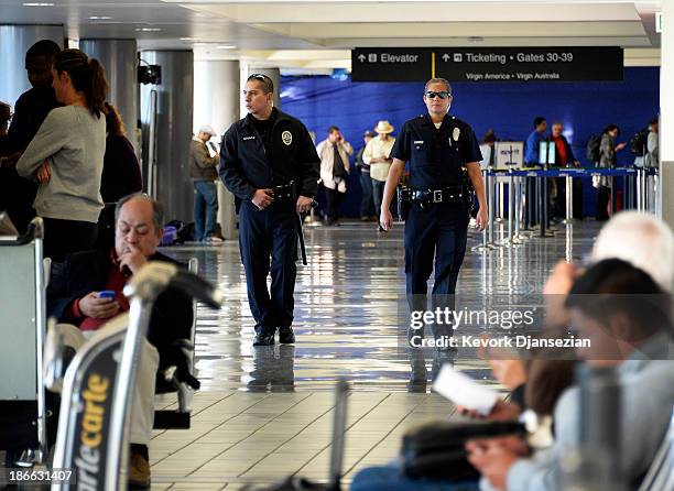 Los Angeles Police Department officers patrol Terminal 2 a day after a shooting that killed one Transportation Safety Administration worker and...