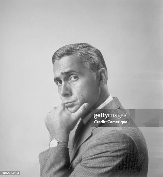 Portrait of businessman facing to the side but looking at the camera with his hand to his chin, July 23, 1966.