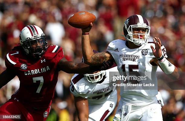 Jadeveon Clowney of the South Carolina Gamecocks tries to stop Dak Prescott of the Mississippi State Bulldogs as he drops back to pass during their...