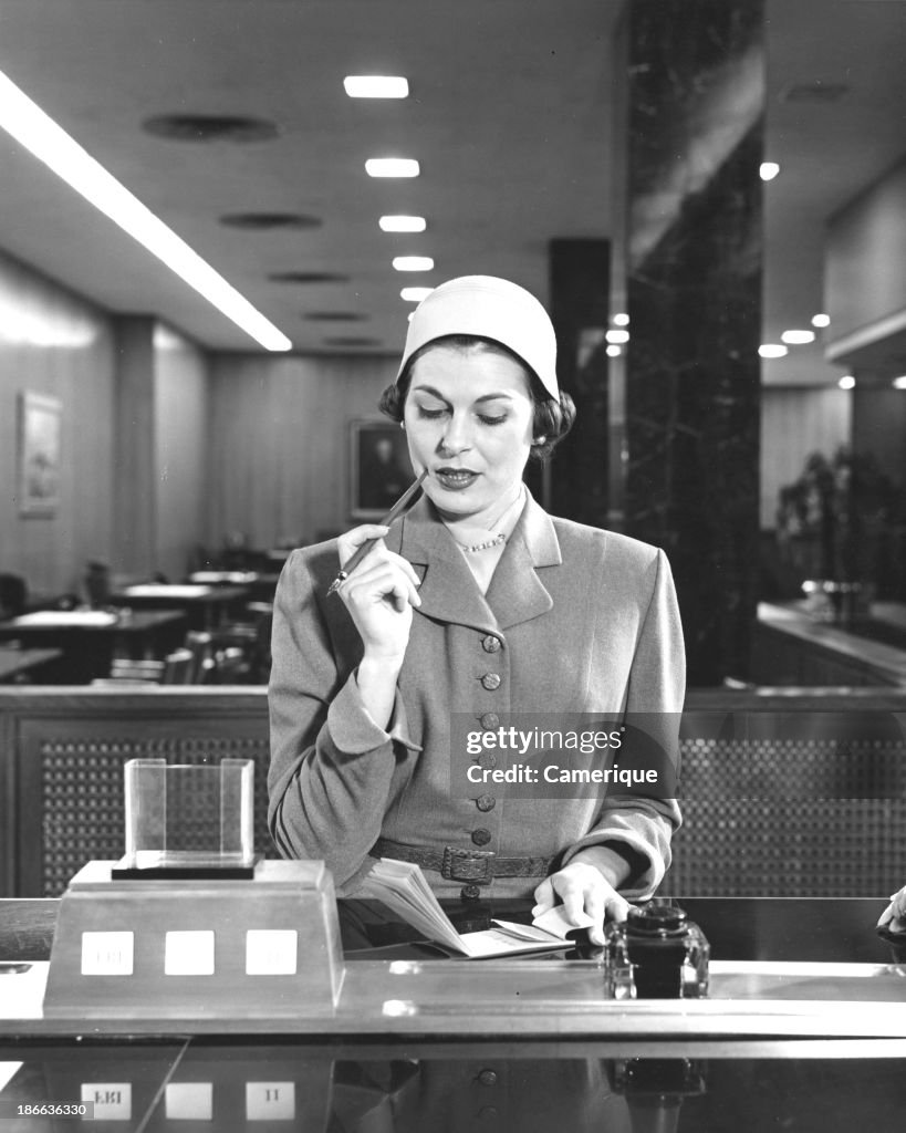 Woman Writing A Check At Bank