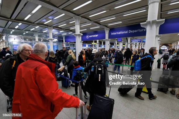 Passengers queue ahead of boarding the Eurostar train at King's Cross St Pancras on December 22, 2023 in London, England. Travel disruptions persist...