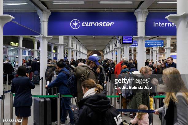 Passengers queue ahead of boarding the Eurostar train at King's Cross St Pancras on December 22, 2023 in London, England. Travel disruptions persist...