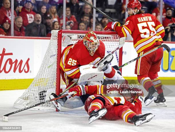 Sam Bennett of the Florida Panthers and Blake Coleman of the Calgary Flames collide with goalie Jacob Markstrom of the Calgary Flames during the...