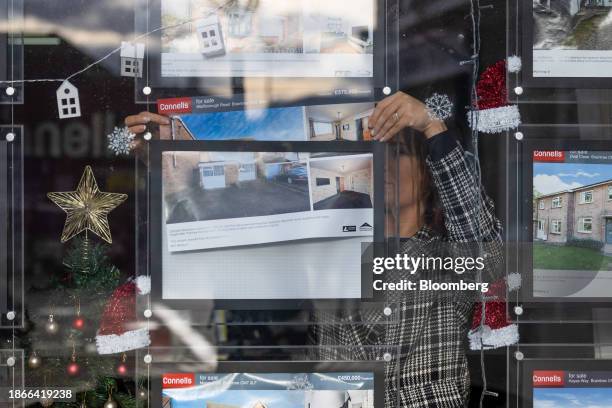 An employee places an advert in the window of an estate agents in Braintree, UK, on Thursday, Dec. 21, 2023. The downturn in the UK housing market...