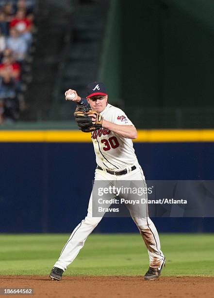 Elliot Johnson of the Atlanta Braves fields a ball against the Philadelphia Phillies at Turner Field on September 28, 2013 in Atlanta, Georgia. The...