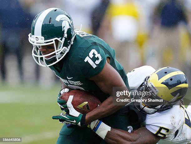 Raymon Taylor of the Michigan Wolverines makes a tackle on Bennie Fowler of the Michigan State Spartans in the first quarter at Spartan Stadium on...