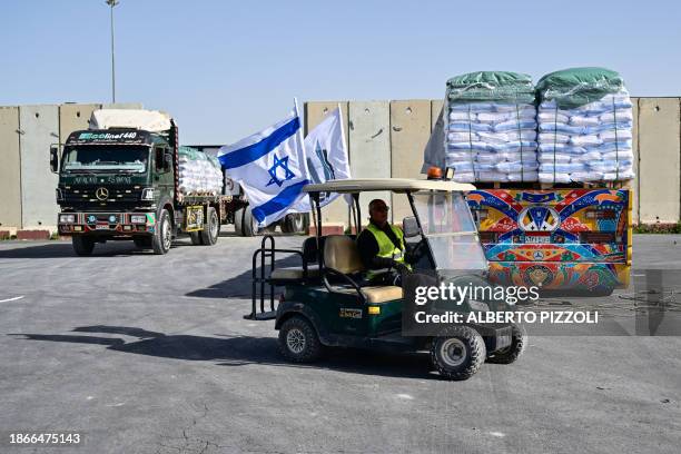Trucks await inspection of their humanitarian aid cargo upon arriving from Egypt on the Israeli side of the Kerem Shalom border crossing with the...
