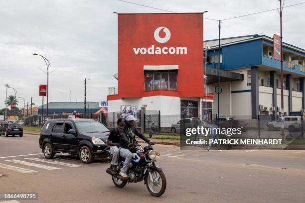 Vehicles drive past a Vodacom building in Lubumbashi on December 22, 2023.