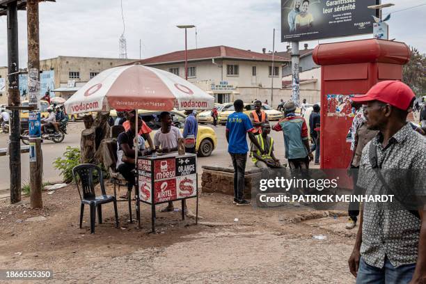 People walk past a Vodacom kiosk in Lubumbashi on December 22, 2023.