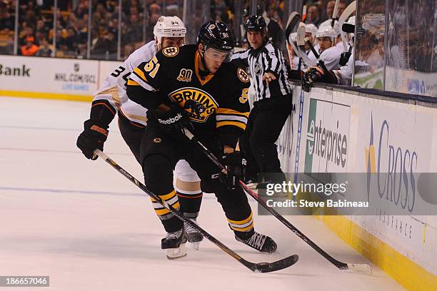 Ryan Spooner of the Boston Bruins fights for the puck against Daniel Winnik of the Anaheim Ducks at the TD Garden on October 31, 2013 in Boston,...