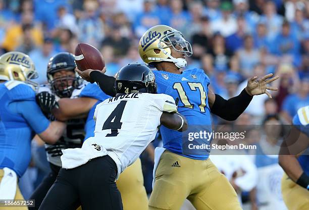 Quarterback Brett Hundley of the UCLA Bruins throws a 76 yard touchdown pass as cornerback Chidobe Awuzie of the Colorado Buffaloes rushes in the...