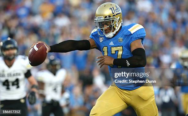 Quarterback Brett Hundley of the UCLA Bruins holds out the ball as he scores on an 11 yard touchdown run in the second quarter against the Colorado...